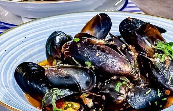 Midii proaspete (in cochilie) cu sos de rosii si patrunjel